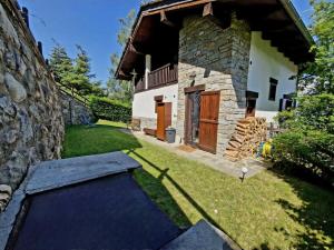un cortile con una casa in pietra con un trampolino di Chalet Grande Cerise - vicino ad Aosta e Pila a Gressan