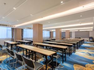 a classroom with tables and chairs in a room at Echarm Hotel Guangzhou North Station Cultural Tourism City in Huadu