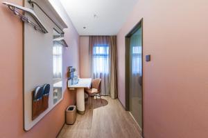 Habitación hospitalaria con escritorio y mesa en Hanting Hotel Shanghai Pudong Airport Shixin Road, en Shanghái