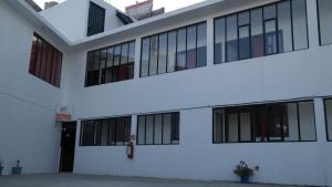 a white building with black windows and a door at Juan Pablo II in San Martín Texmelucan de Labastida