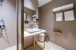 un baño con lavabo y espejo en Hanting Hotel Shanghai Pudong Airport Shixin Road, en Shanghái 32 fotos más