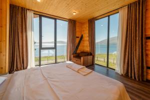 Cottage Tabatskuri في Molit'i: غرفة نوم بسرير كبير ونوافذ كبيرة