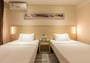City Comfort Inn Wuhan Jiefang Avenue Xinrong Light Rail Station في ووهان: غرفة فندقية تحتوي على سريرين في الغرفة +166 صورة