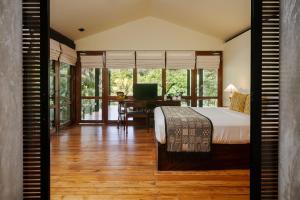 a bedroom with a bed and a desk with a computer at Jetwing Kurulubedda - Adults Only in Galle