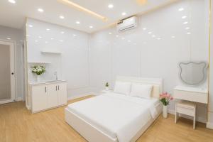 ホーチミン・シティにあるH2T Hotel VanHanhSmallの白いベッドルーム(白いベッド1台、シンク付)