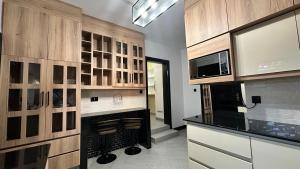a kitchen with a fireplace and wooden cabinets at Beauty Blender Homes - The Executive House in Lilongwe