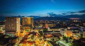 a city lit up at night with buildings at RoomQuest Chiang Mai Tha Sala in Chiang Mai +36 photos