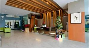 The Crew Hotel Kualanamu International Airport في Kampungbesar: لوبي مع شجرة عيد الميلاد في وسط مبنى