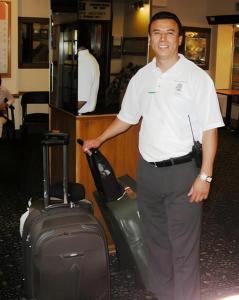 a man standing with a suitcase in an airport at Hotel Harrington in Washington
