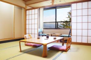 a room with a table and chairs and a window at Miyajima Morinoyado in Miyajima