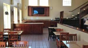 a restaurant with tables and chairs and a flat screen tv at Arden Star Hotel in Arden Town