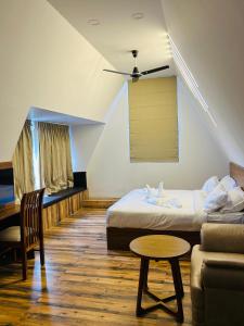 ein Zimmer mit einem Bett, einer Couch und einem Tisch in der Unterkunft Mangalath River View Resorts in Kodanad + 3 Fotos