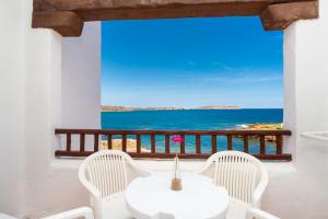 a white table and chairs with a view of the ocean at Comitas Tramontana Park in Fornells