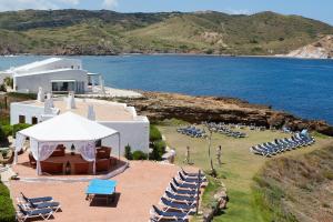 a group of lounge chairs and a beach with the ocean at Comitas Tramontana Park in Fornells