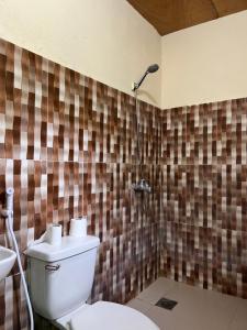 a bathroom with a toilet and a shower at Sharky Hostel Oslob in Oslob
