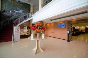 a lobby with a table with flowers on it at Garuda Hotel Pontianak in Siantan