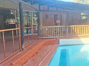 a swimming pool on a patio with a building at SMAPERS GUESTHOUSE in Brits