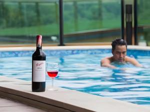 a bottle of wine and a glass in a swimming pool at Chantara Valley Resort in Ban Sap Bon
