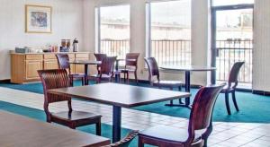 una sala de espera con mesas, sillas y ventanas en Knights Inn South Houston TX, en Houston