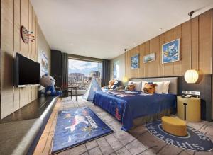 a bedroom with a large blue bed with stuffed animals on it at DongGuan JOYC Hotel  in Dongguan