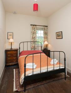 a bedroom with a bed and two night stands and a window at Magherintemple Lodge in Ballycastle