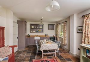 eine Küche und ein Esszimmer mit einem Tisch und Stühlen in der Unterkunft Magherintemple Lodge in Ballycastle
