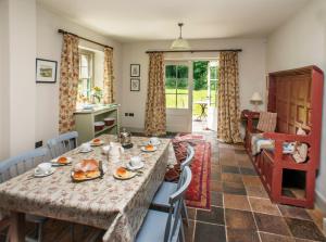 a kitchen and living room with a table and chairs at Magherintemple Lodge in Ballycastle