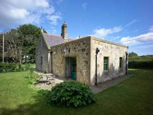 an old stone building with a green door at Magherintemple Lodge in Ballycastle