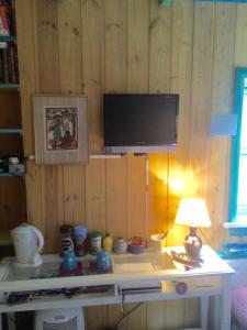 a room with a table with a tv on a wall at Annehelenes B&B in Bergen