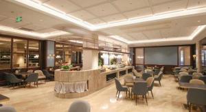 a restaurant with chairs and tables and a bar at Nanjing Grand Da Qiao Hotel in Nanjing