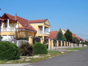 una casa con una valla delante de una calle en Georgina Apartman, en Harkány