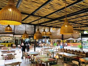 a restaurant with tables and chairs and pendant lights at Borala Lake Weligama in Weligama