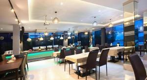 a restaurant with tables and chairs and a bar at UDTel Boutique Hotel Udonthani in Ban Dong Kheng