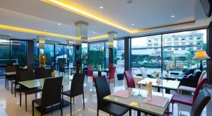 a restaurant with tables and chairs and windows at UDTel Boutique Hotel Udonthani in Ban Dong Kheng