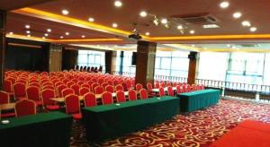 a banquet hall with red chairs and green tables at GreenTree Inn Huzhou South Street Chaoyin Bridge Business Hotel in Huzhou