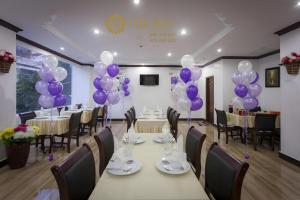 a banquet hall with purple balloons and tables and chairs at The Mou Hotel in Phnom Penh