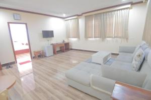 a living room with a white couch and a table at The Mou Hotel in Phnom Penh