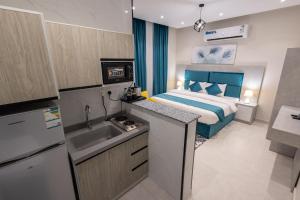 Una cocina con fregadero y una cama en una habitación. en شقق الضيافة الخاصه, en Yeda