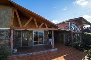 a house with a wooden roof and a patio at Cabañas Matavai in Hanga Roa