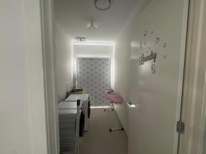 een witte badkamer met een wastafel en een spiegel bij Nine in Grovedale +19 foto's