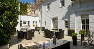 un patio avec des tables et des chaises en face d'un bâtiment dans l'établissement Design-Hotel Zur Abtei, à Aix-la-Chapelle