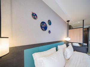 Un dormitorio con una cama y platos en la pared en 凤凰县三三民宿, en Hanqiyu