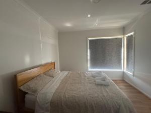 een slaapkamer met een groot bed en een raam bij Nine in Grovedale