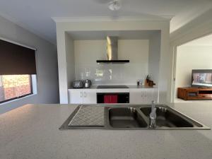 een keuken met een spoelbak en een aanrechtblad bij Nine in Grovedale