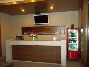 南芭堤雅Honey Lodge的带电视和红色冰箱的酒吧