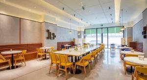 Un comedor con mesas y sillas amarillas. en GreenTree Inn Shanghai National Convention and Exhibition Center Huaxiang Road, en Shanghái