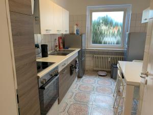 eine kleine Küche mit Spüle und Fenster in der Unterkunft Villa Porta Westfalica in Porta Westfalica