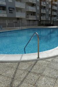 a swimming pool with a hand rail in front of a building at la loma in Torrevieja