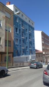 un edificio azul al lado de una calle en Apartamento Los Colonia, en Burgos