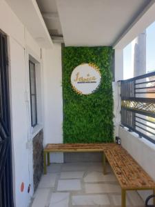 een bankje voor een groene muur bij Fernica Boarding House in Carmona